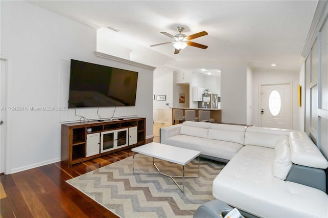 living room featuring ceiling fan, dark hardwood / wood-style floors, and ornamental molding