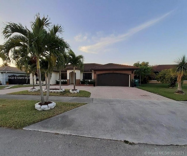 view of front of property featuring a yard and a garage