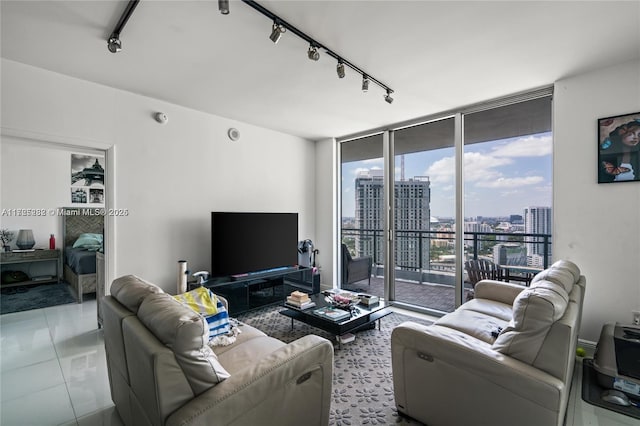 living room with track lighting, a wall of windows, and light tile patterned floors