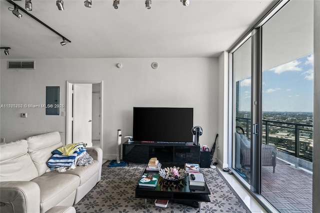 living room with electric panel, track lighting, and a wall of windows