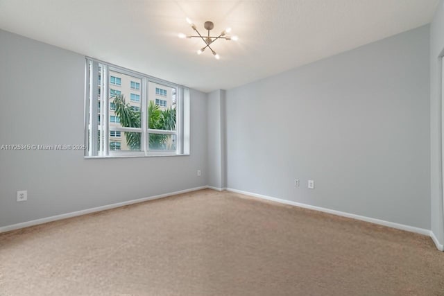 carpeted empty room featuring a notable chandelier