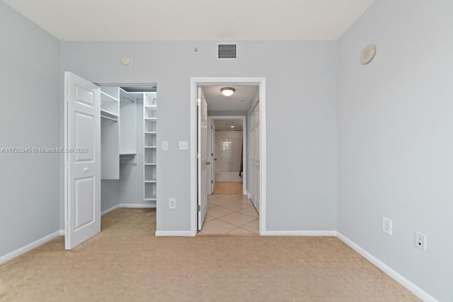 unfurnished bedroom with a closet and light carpet