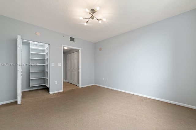 unfurnished bedroom with light colored carpet and an inviting chandelier