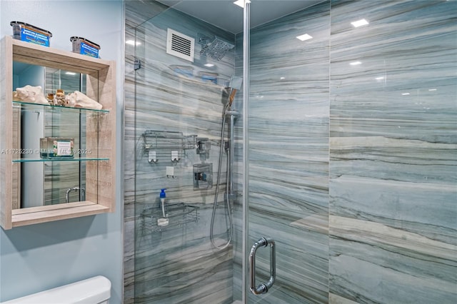 bathroom with toilet and a shower with shower door