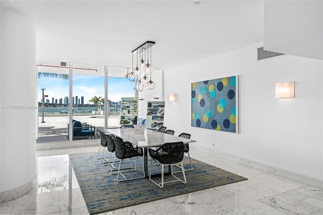 dining space with a wall of windows and a notable chandelier