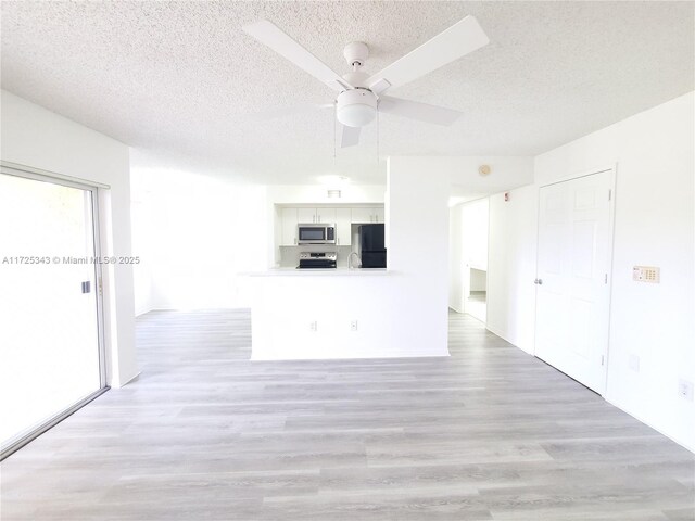 2600 S University Dr Unit 218, Davie, FL 33328 - unfurnished living room with baseboards, light wood-style flooring, a ceiling fan, and a textured ceiling