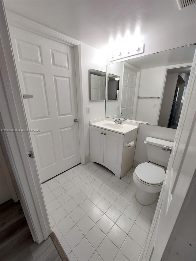 bathroom with tile patterned flooring, vanity, and toilet