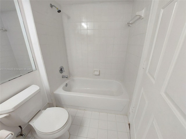 bathroom featuring tiled shower / bath combo, tile patterned floors, and toilet