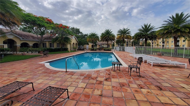 community pool featuring fence and a patio area