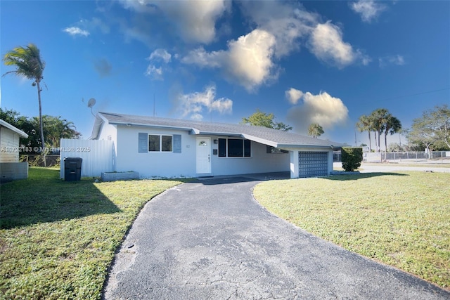 ranch-style home featuring a garage and a front lawn