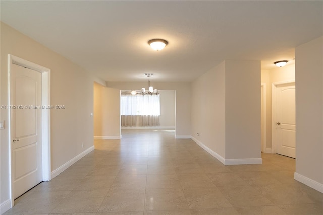 unfurnished room with a chandelier