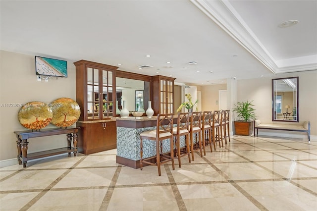 bar with ornamental molding and a tray ceiling