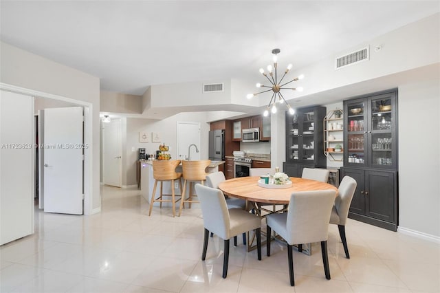 tiled dining area featuring sink and a chandelier