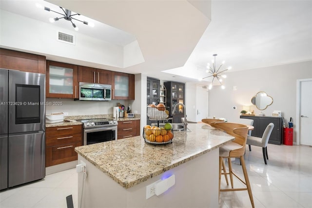 kitchen featuring sink, a center island with sink, a breakfast bar area, and appliances with stainless steel finishes