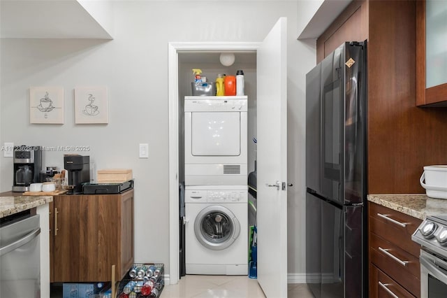 washroom featuring light tile patterned floors and stacked washer / dryer