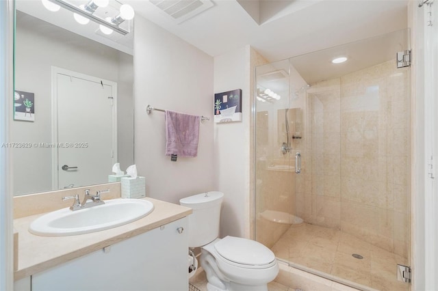 bathroom with toilet, vanity, tile patterned floors, and a shower with shower door