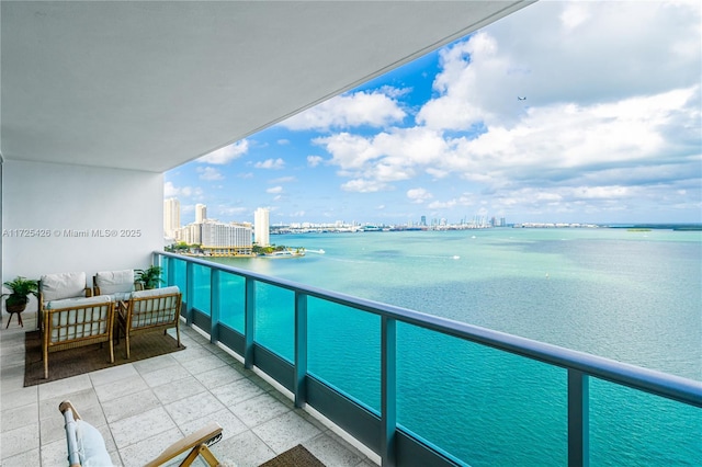 balcony featuring an outdoor living space and a water view