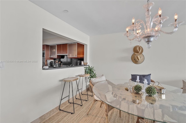 dining space with light hardwood / wood-style floors and a notable chandelier