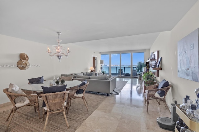 dining room with an inviting chandelier, floor to ceiling windows, and a water view