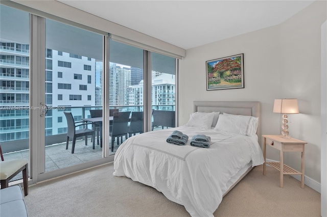 bedroom with a wall of windows, carpet floors, and access to outside