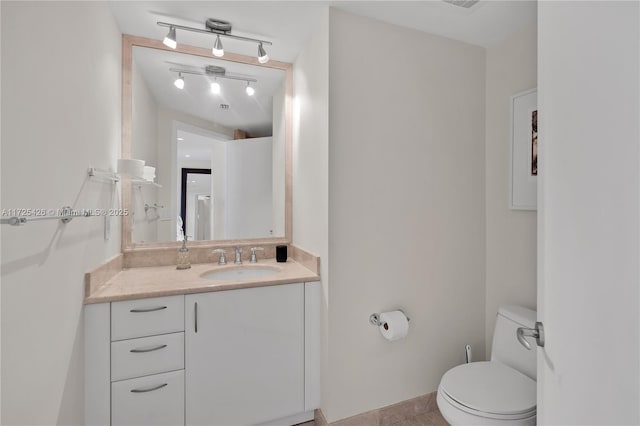 bathroom with toilet, tile patterned floors, and vanity