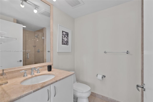 bathroom featuring toilet, a shower with shower door, tile patterned floors, and vanity