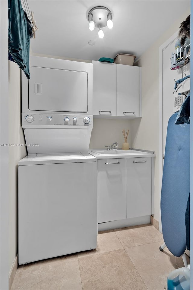 laundry room with stacked washing maching and dryer, cabinets, and sink