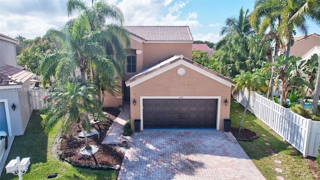 mediterranean / spanish home with a garage and a front lawn