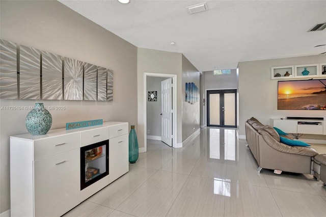 interior space with light tile patterned floors and french doors