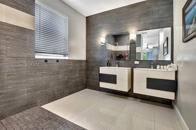 bathroom featuring ceiling fan, tiled shower, vanity, and tile patterned flooring