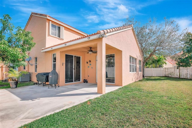 rear view of property with a patio, ceiling fan, and a lawn