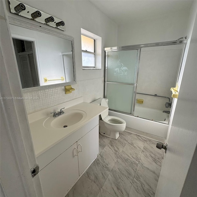 full bathroom featuring enclosed tub / shower combo, decorative backsplash, vanity, and toilet