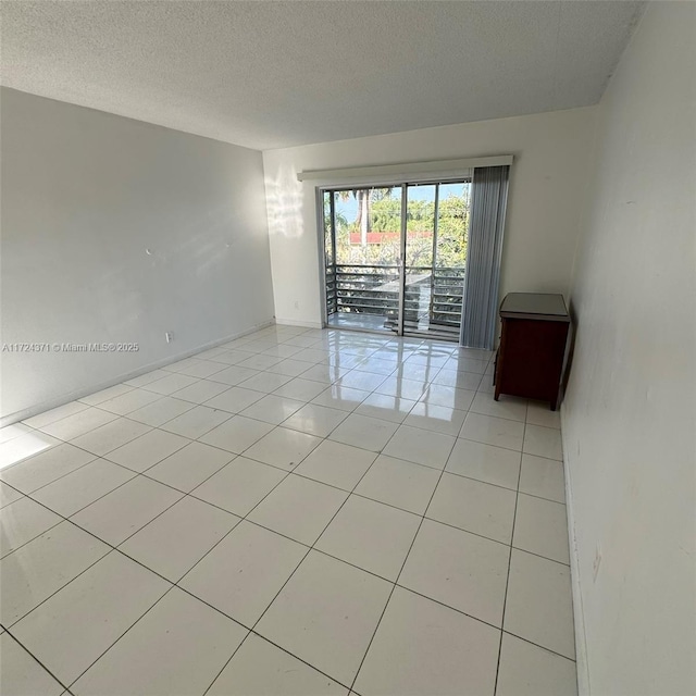 tiled empty room with a textured ceiling