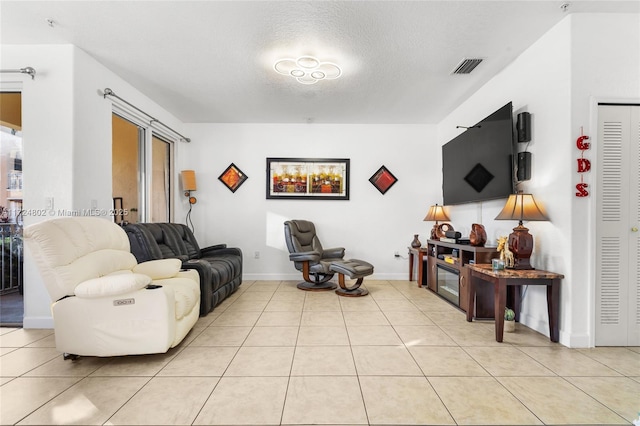 tiled living room featuring a textured ceiling