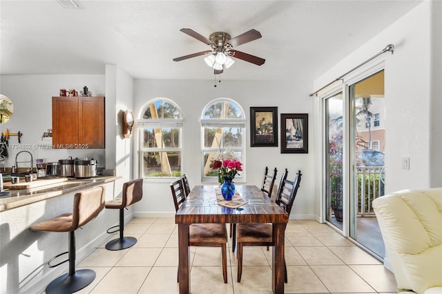 dining room with light tile patterned floors, a wealth of natural light, and ceiling fan