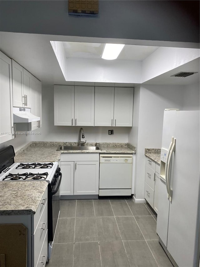 kitchen with sink, white appliances, white cabinetry, and light tile patterned floors