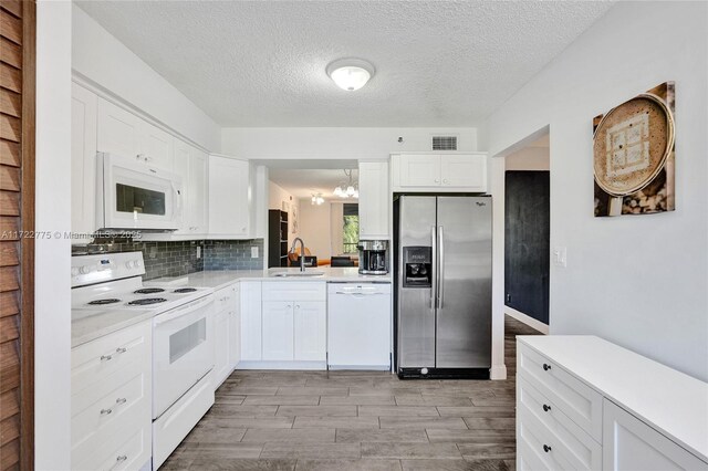 4570 NW 18th Ave Unit 202, Deerfield Beach, FL 33064 - laundry area featuring stacked washer and clothes dryer, wood finished floors, and a textured ceiling