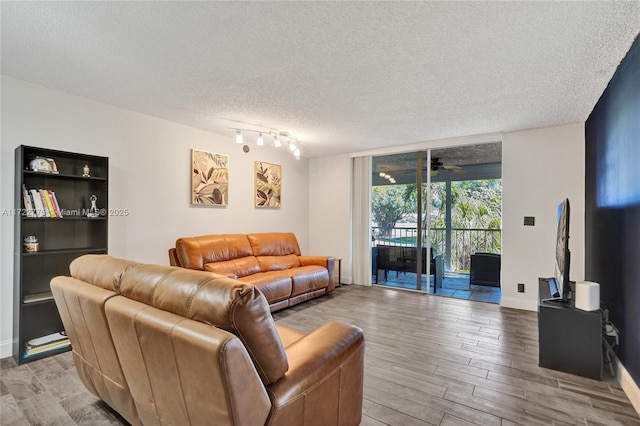 living room with floor to ceiling windows, ceiling fan, and a textured ceiling