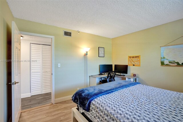 4570 NW 18th Ave Unit 202, Deerfield Beach, FL 33064 - bedroom featuring wood finished floors, a closet, a textured ceiling, and baseboards