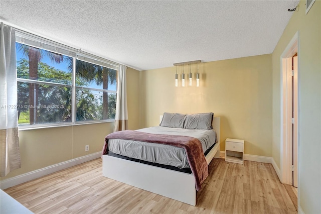 bedroom featuring a textured ceiling and light wood-type flooring