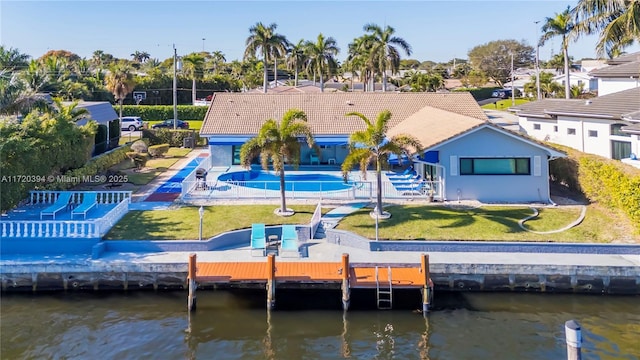 rear view of house with a yard and a water view