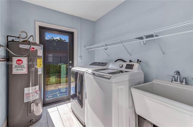 laundry room with sink, electric water heater, and independent washer and dryer