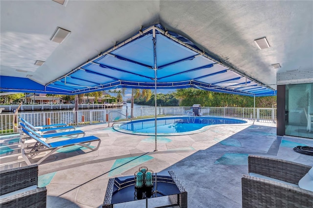 view of pool with a patio and a water view