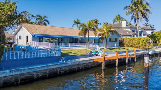 dock area with a yard, a swimming pool, and a water view