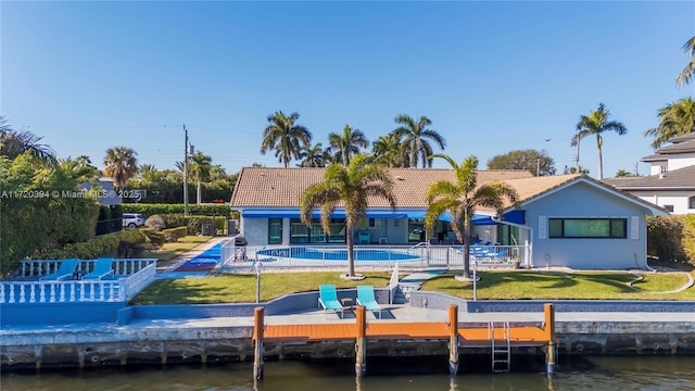 rear view of property with a patio, a yard, and a water view