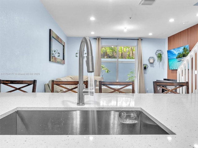 kitchen with light stone counters and sink