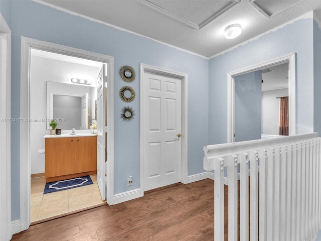 hallway featuring a textured ceiling, hardwood / wood-style floors, radiator heating unit, and sink