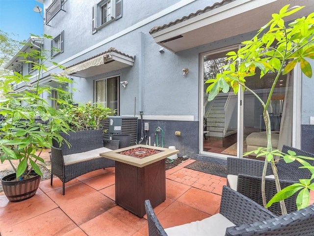 view of patio / terrace featuring central air condition unit and a fire pit