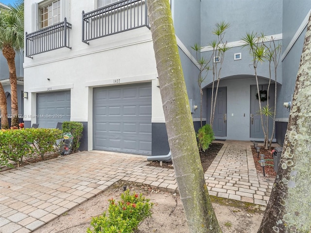 view of front of property featuring a balcony and a garage