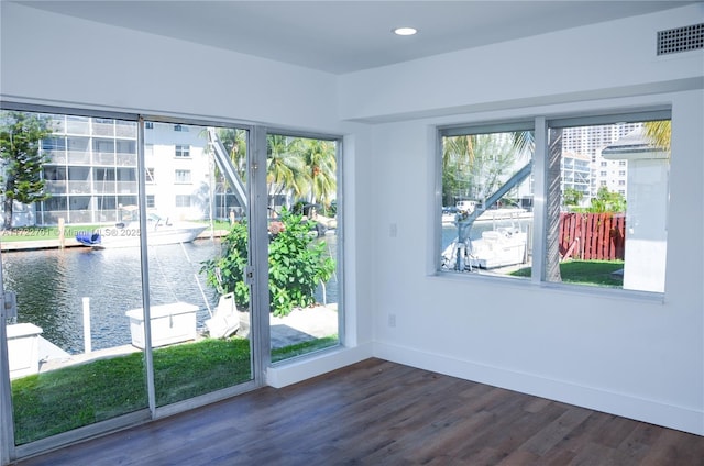 doorway to outside with dark hardwood / wood-style flooring and a water view